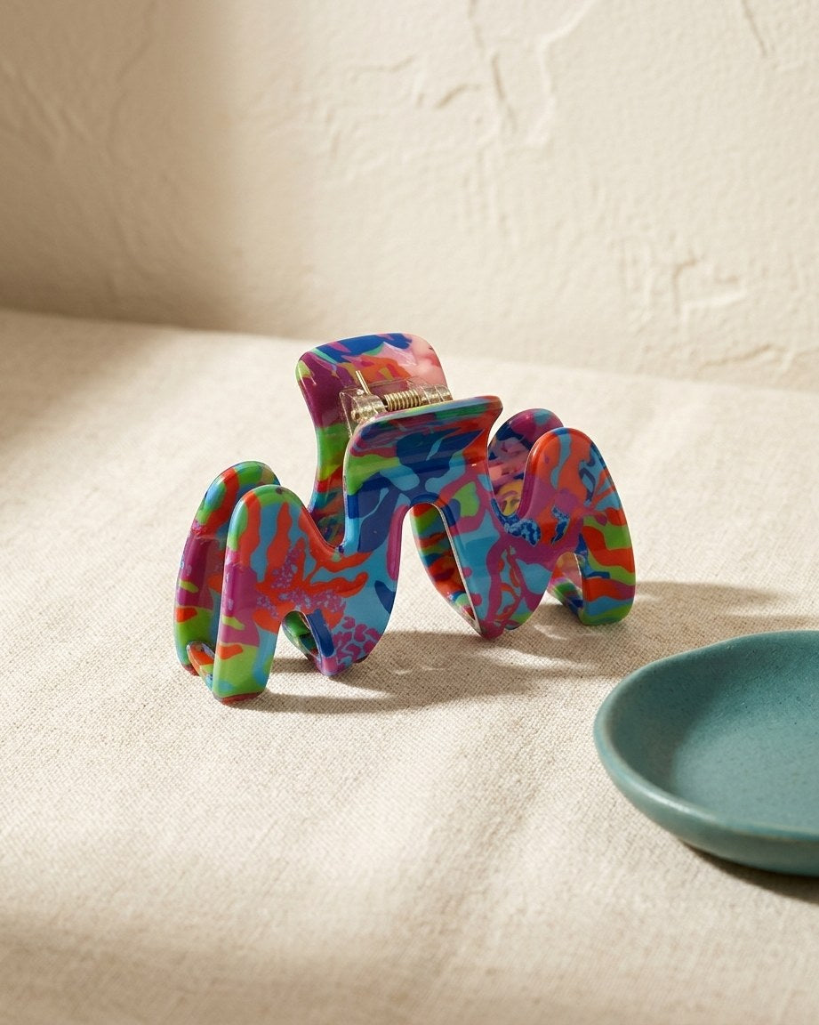 Wavy acetate claw clip on a cream linen table
